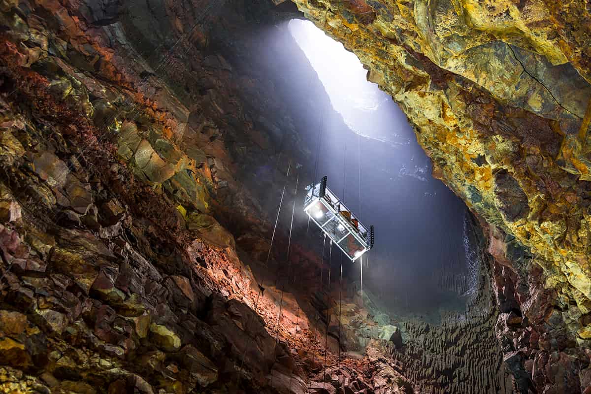 Inside the dormant Þríhnúkagígur volcano in Iceland, showing colorful magma chamber walls and a viewing platform