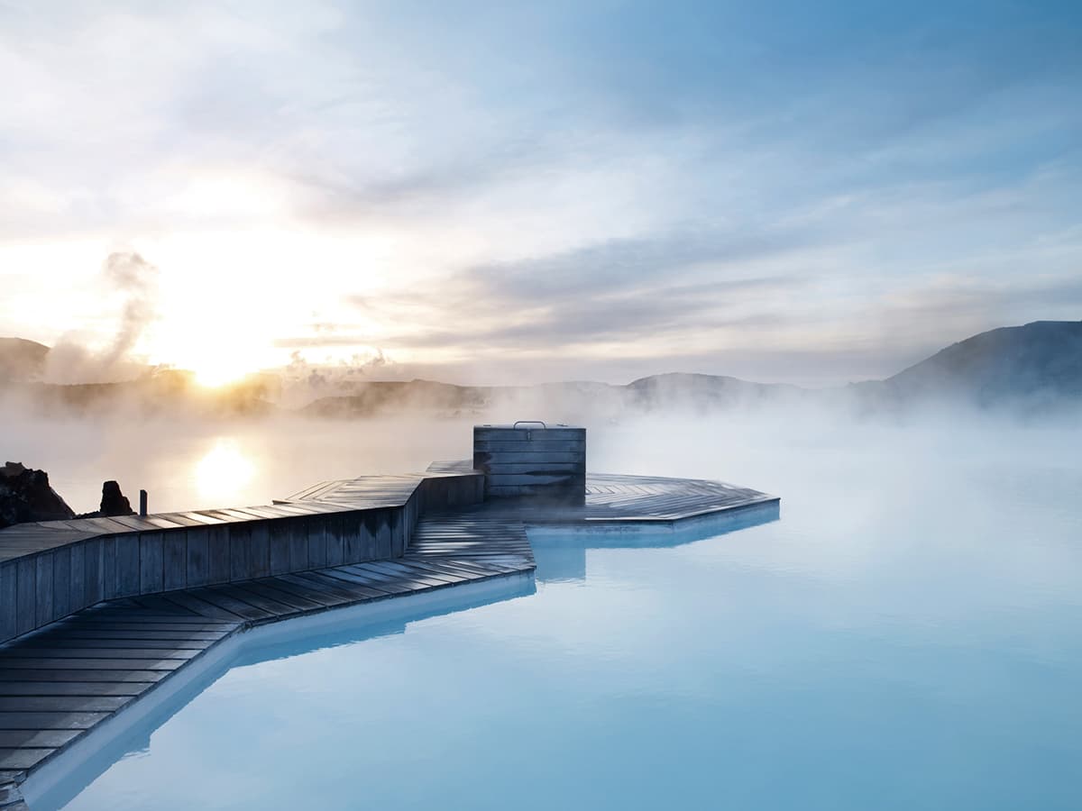 The Blue Lagoon geothermal spa in Iceland with milky blue waters surrounded by black lava fields and rising steam