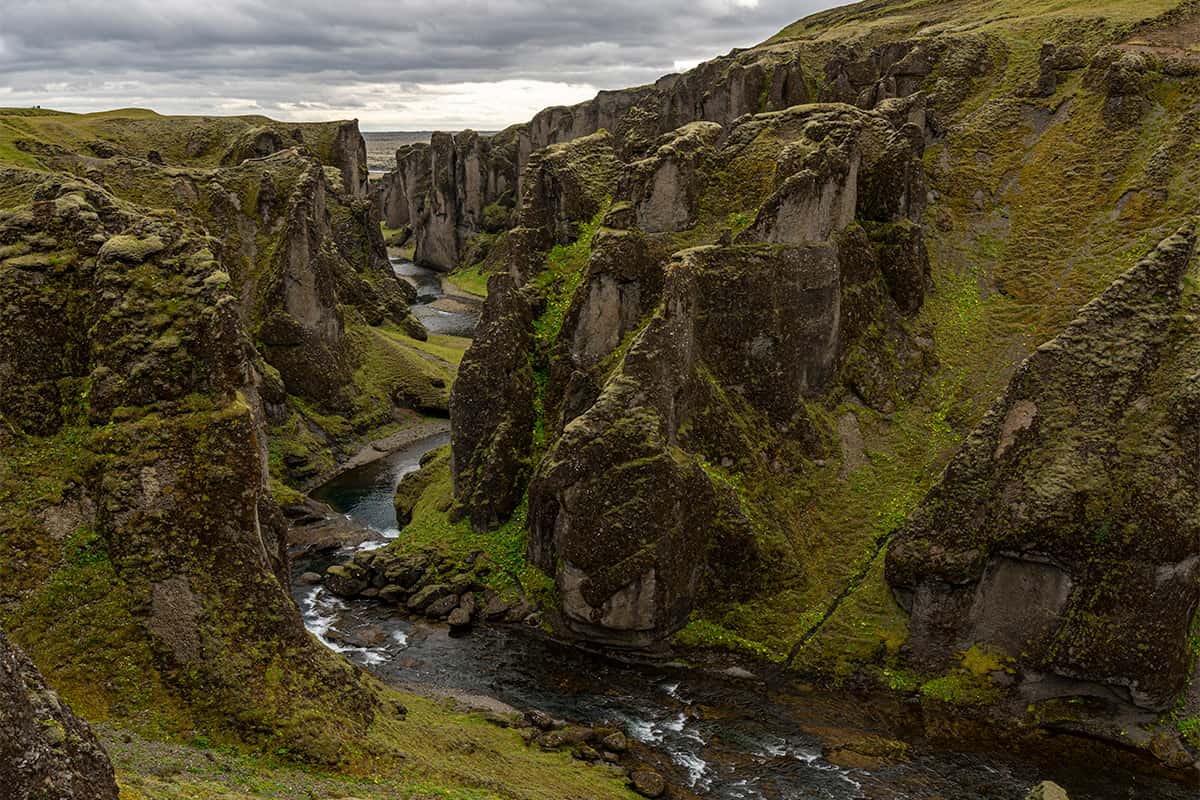 Fjaðrárgljúfur canyon in South Iceland with steep moss-covered cliffs and a winding river below