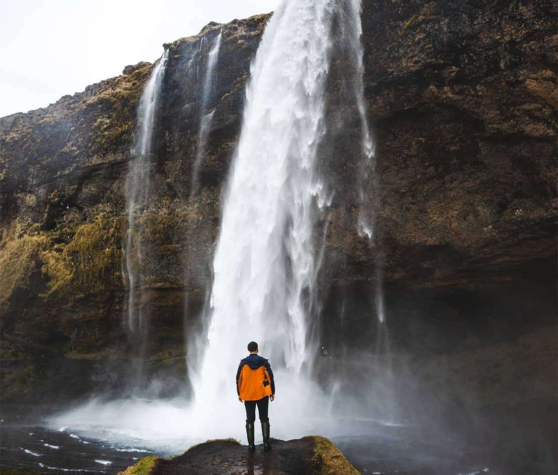 Seljalandsfoss waterfall in South Iceland, with a walking path behind the cascading water and lush green cliffs