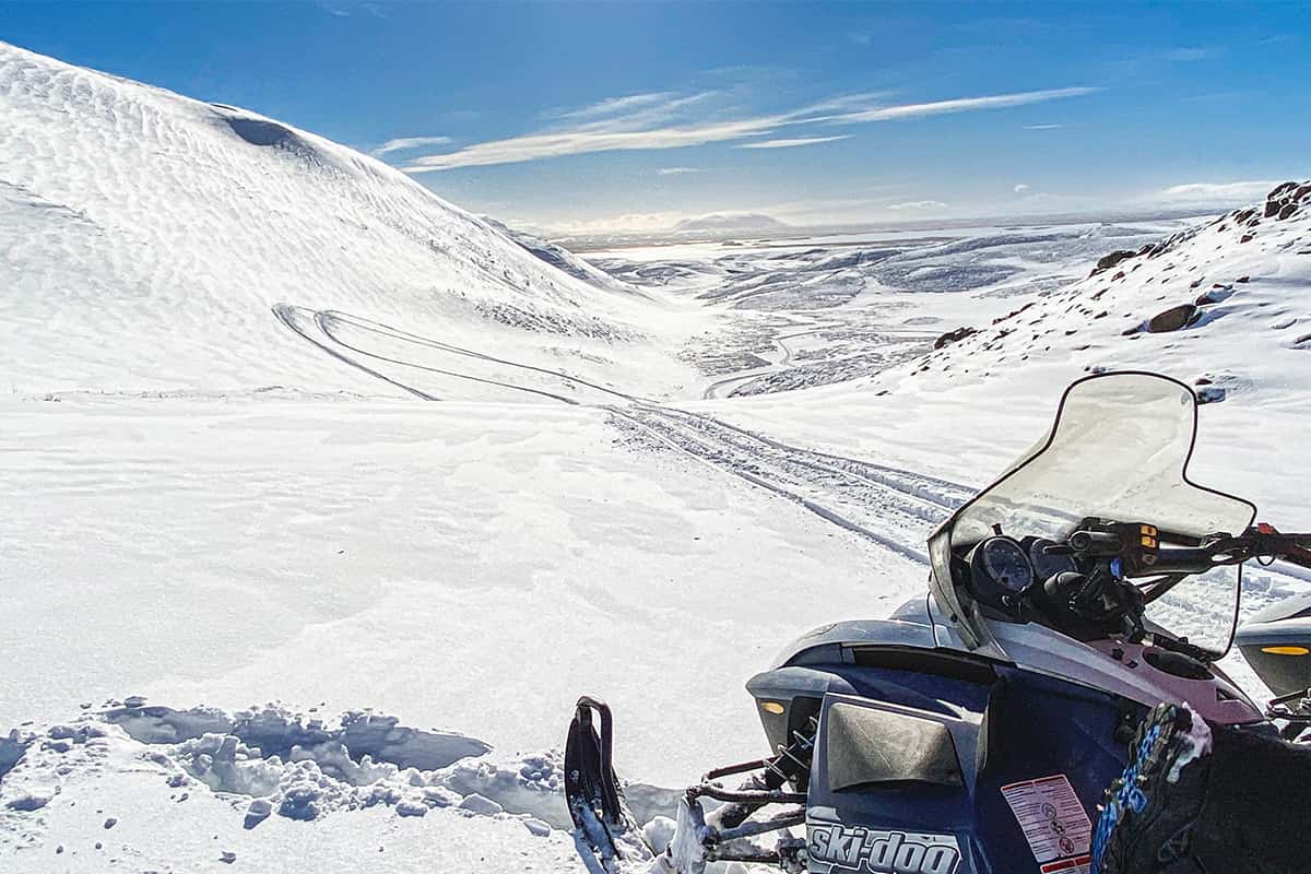 Snowmobile adventure across an Icelandic glacier with snowy landscapes and mountain views