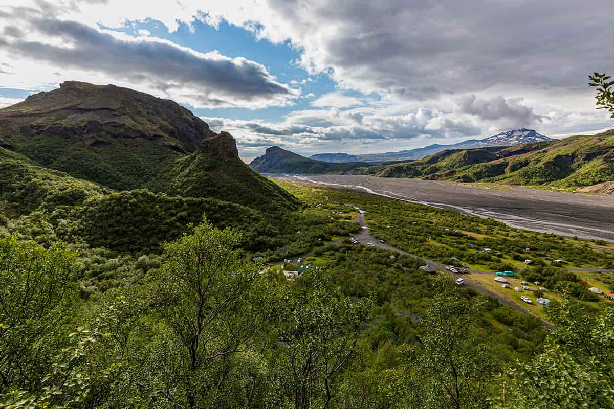 Þórsmörk valley in Iceland with lush green landscapes, dramatic cliffs, braided glacial rivers, and surrounding glaciers under a moody sky