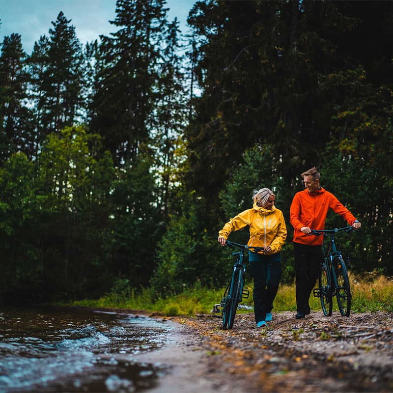 Cyclist riding along the Halden Canal in Norway with forested trails calm water and scenic locks in a peaceful outdoor adventure setting