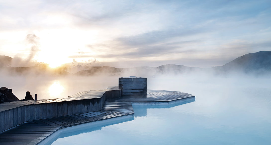 Steaming turquoise waters of the Blue Lagoon in Iceland surrounded by black lava fields and misty atmosphere in a peaceful geothermal setting
