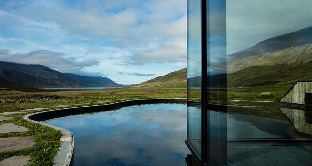 Secluded luxury lodge in the Troll Peninsula North Iceland surrounded by rugged peaks offering adventure wellness and scenic tranquility