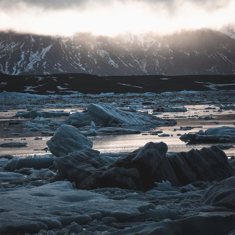 Icebergs floating in the glacial lagoon at Jökulsárlón in Southeast Iceland with Vatnajökull glacier visible in the background