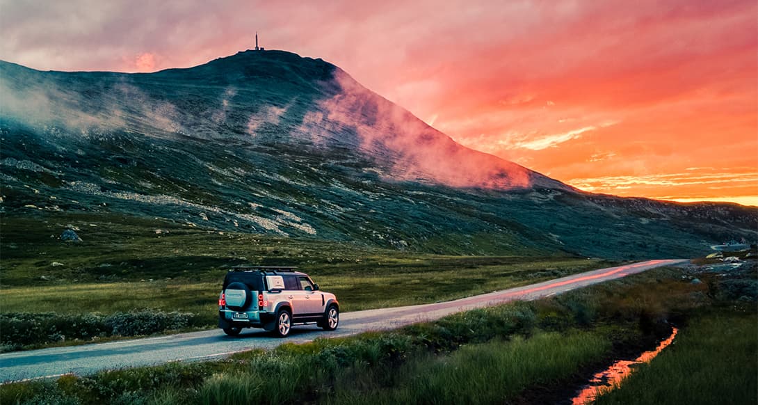 Scenic road leading toward Gaustatoppen mountain in Norway with dramatic peaks and open skies evoking a sense of Nordic exploration and freedom