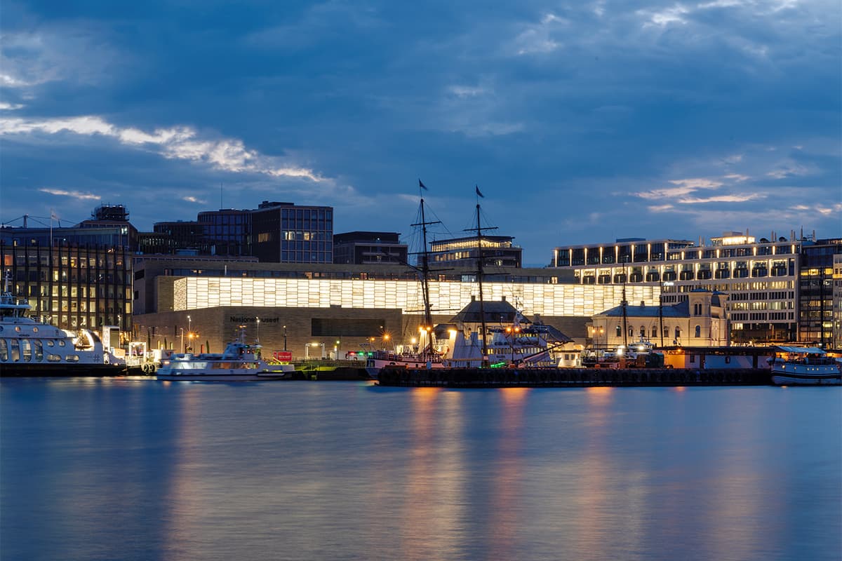 View of the National Museum in Oslo Norway seen from a wooden pier with calm water and modern architecture in a cultural waterfront setting