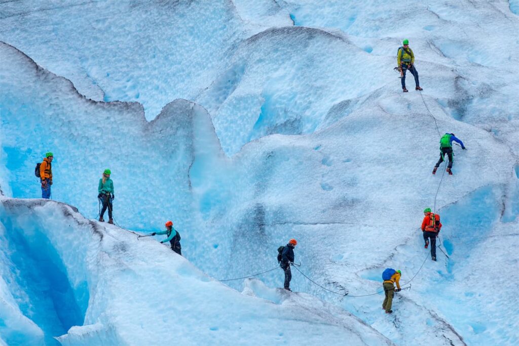 glacier walking experience on Enga Breen in Norway with travelers exploring icy terrain in a dramatic arctic adventure setting