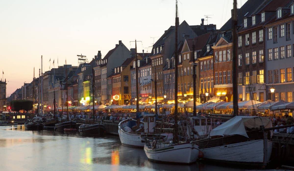 Nyhavn canal in Copenhagen at night with colorful buildings and reflections on the water